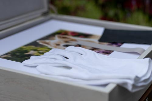 weiße Handschuhe und schwarzes Satintuch liegen auf einer offenen Window Folio Box