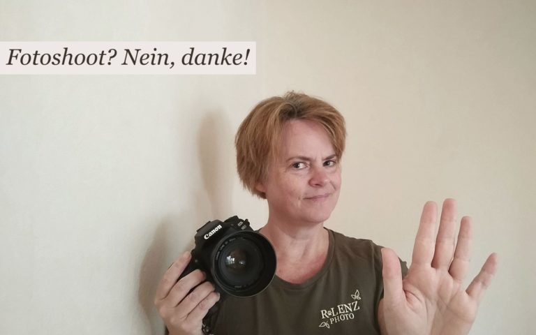 Frau mit Fotokamera schaut skeptisch und hält ihre Hand abweisen in die Höhe. Der Text sagt "Fotoshoot? Nein, danke!"