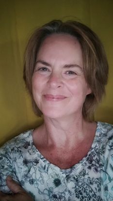 Selbstportrait Rebecca lächelnd vor gelbem Hintergrund