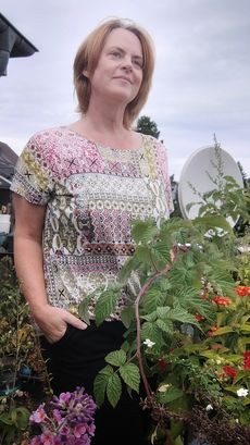Selbstportrait Rebecca stehend zwischen Balkonpflanzen